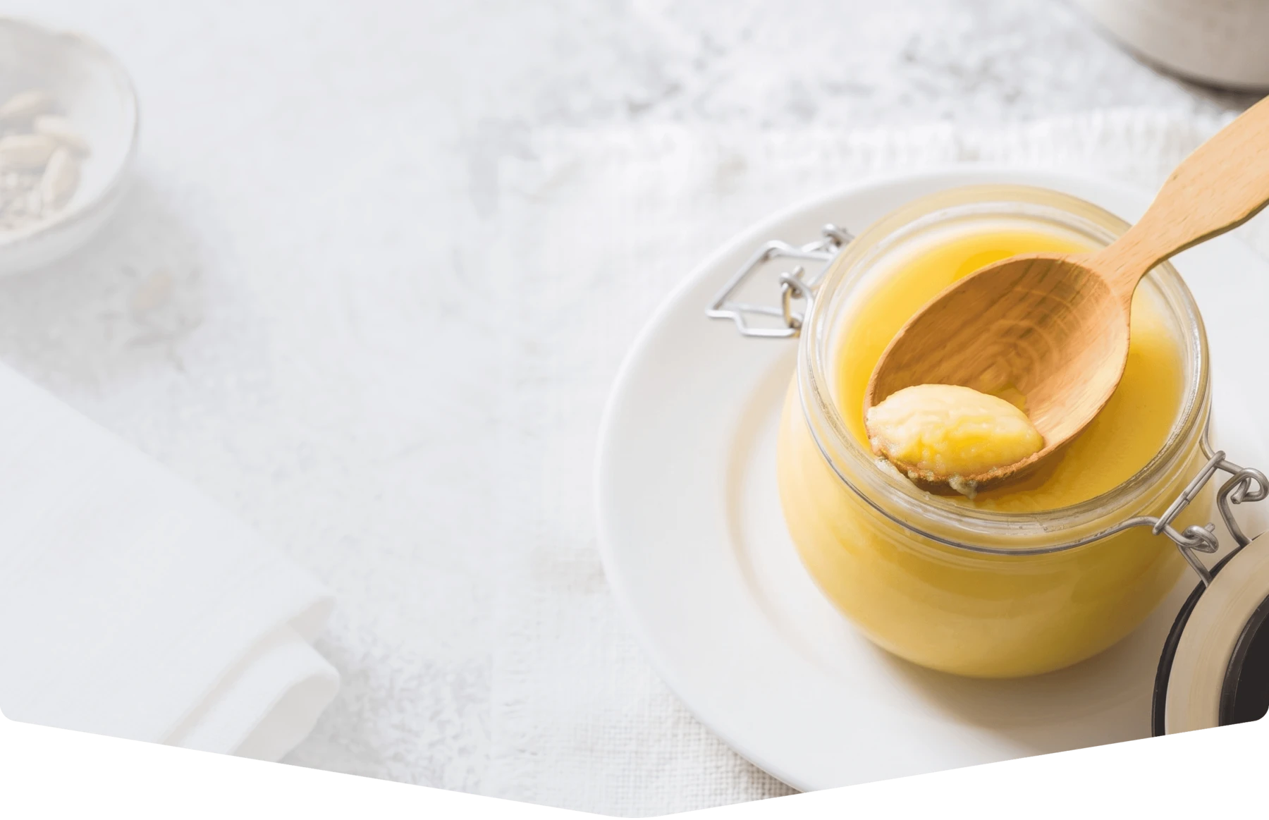A jar of golden ghee with a wooden spoon